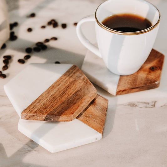 White mug with coffee on geometric wooden and marble coasters